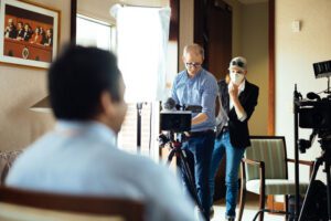 JEM Associate Professor Nick Geidner, left, sets up a camera with a student as part of a Land Grant Films interview.