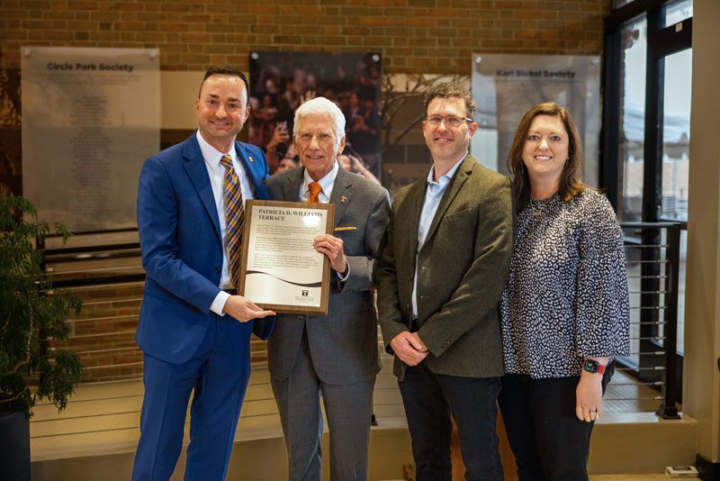 From left, Dean Joe Mazer and JEM alumnus John Williams hold a plaque dedicating the third-floor Communication and Information Building terrace to Patricia Williams. To the left are Thomas and Elizabeth Williams.